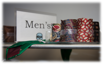 Several rolled up, professional ties for men at the Start Here, Go Far Boutique.