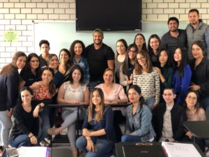 A group photo of students and staff posed in a classroom setting. 