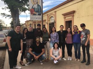 Twelve students smiling on the sidewalk in Mexico. 