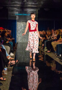 A model walks down the fashion runway head held high. 