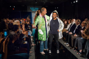 The president of the college and a student pose at the end of the fashion runway! 