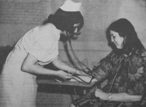 Nursing student checking vitals of another student. 