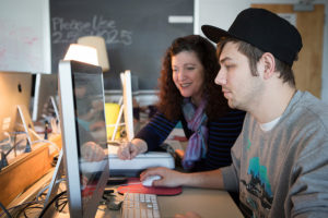 Young man and professor work together on a desktop computer.