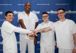4 male nursing students posed together smiling. 