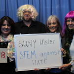 Faculty holding STEM against hate NOh8 whiteboard