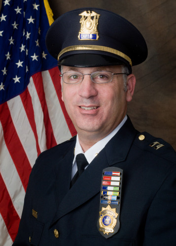 Ron Spero poses in front of American flag
