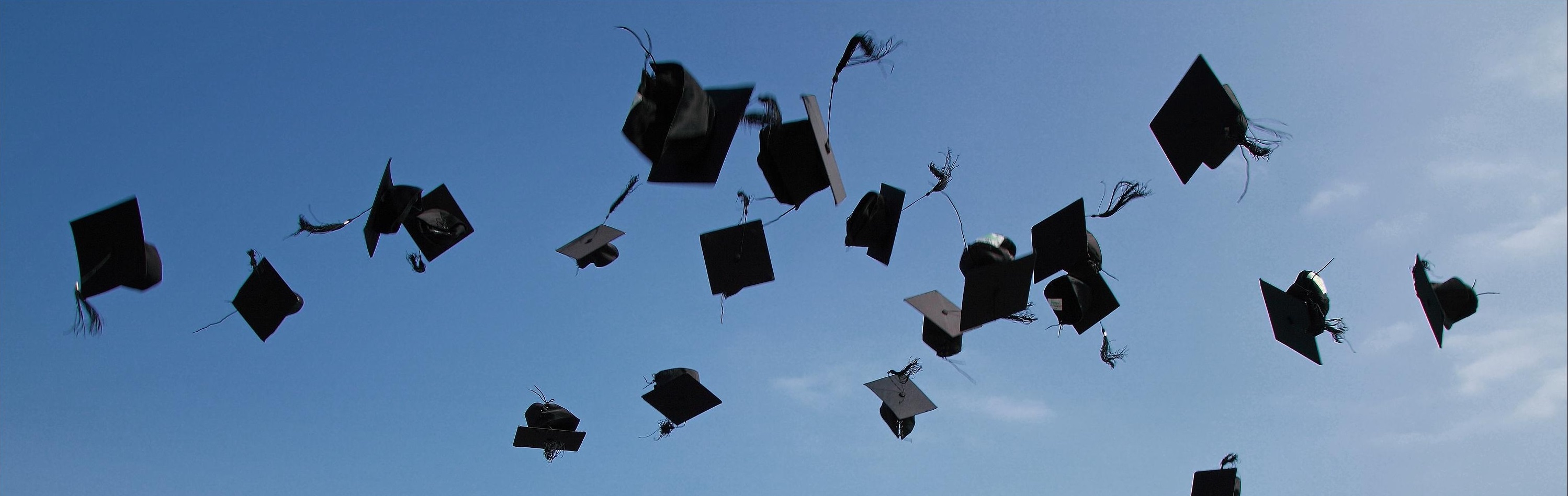 Graduation caps in midair