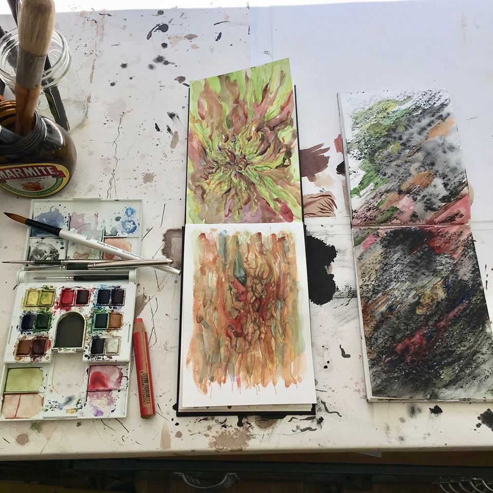 open sketchbooks and watercolor sets