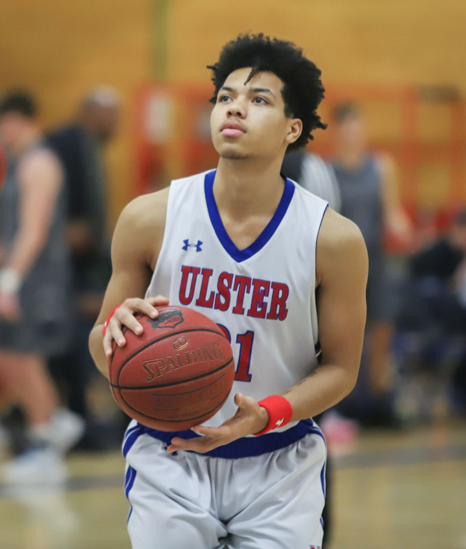 Student with Ulster jersey holding basketball, in action on the court