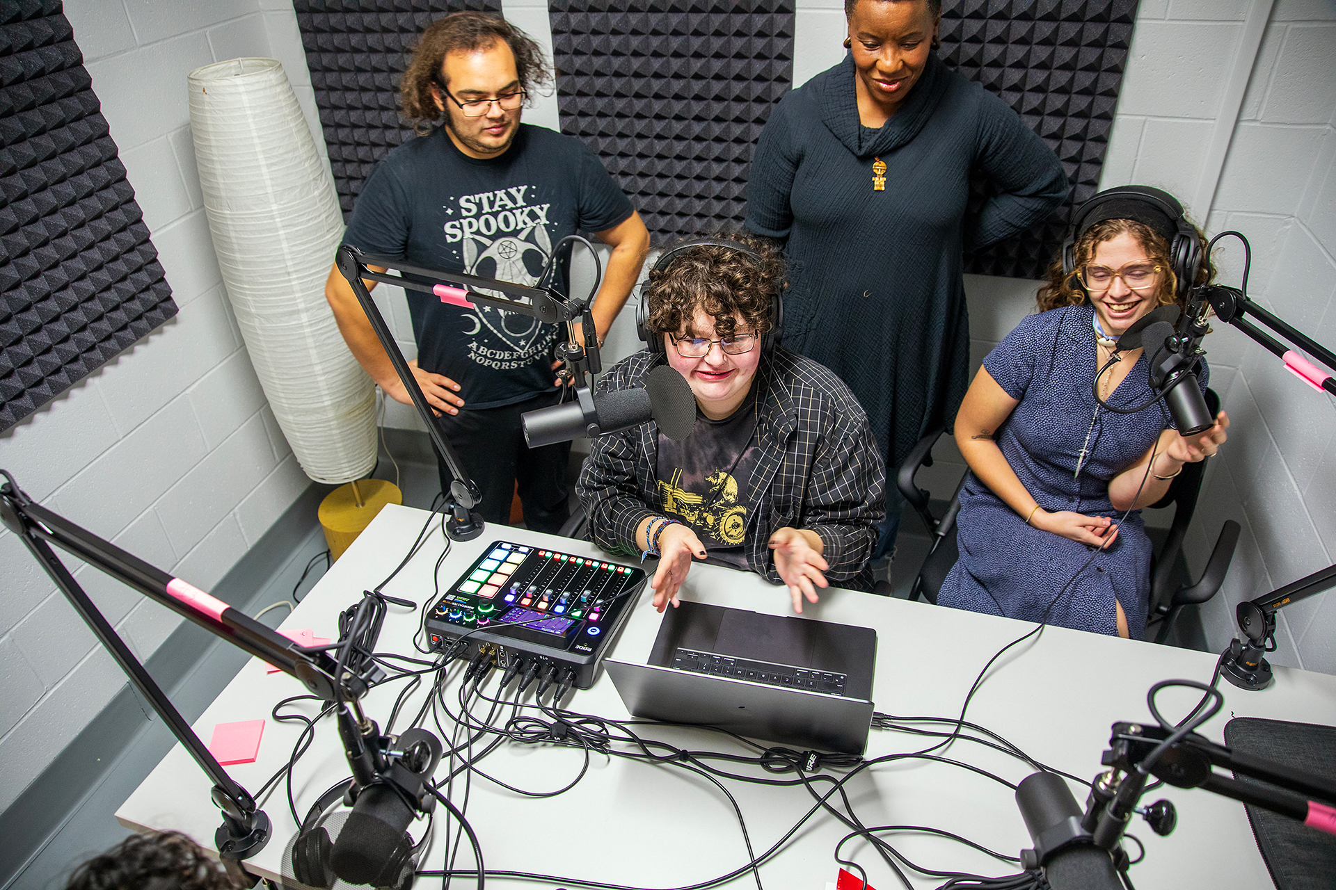 four students in a broadcast room with pro audio gear
